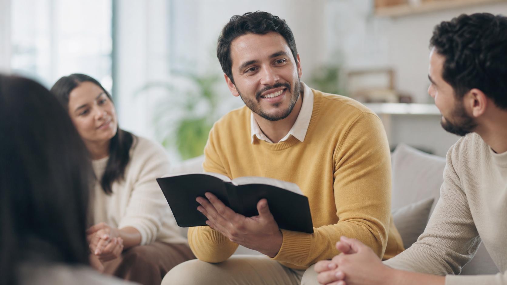 Lider de celula com Biblia na mao conversando com o grupo na sala
