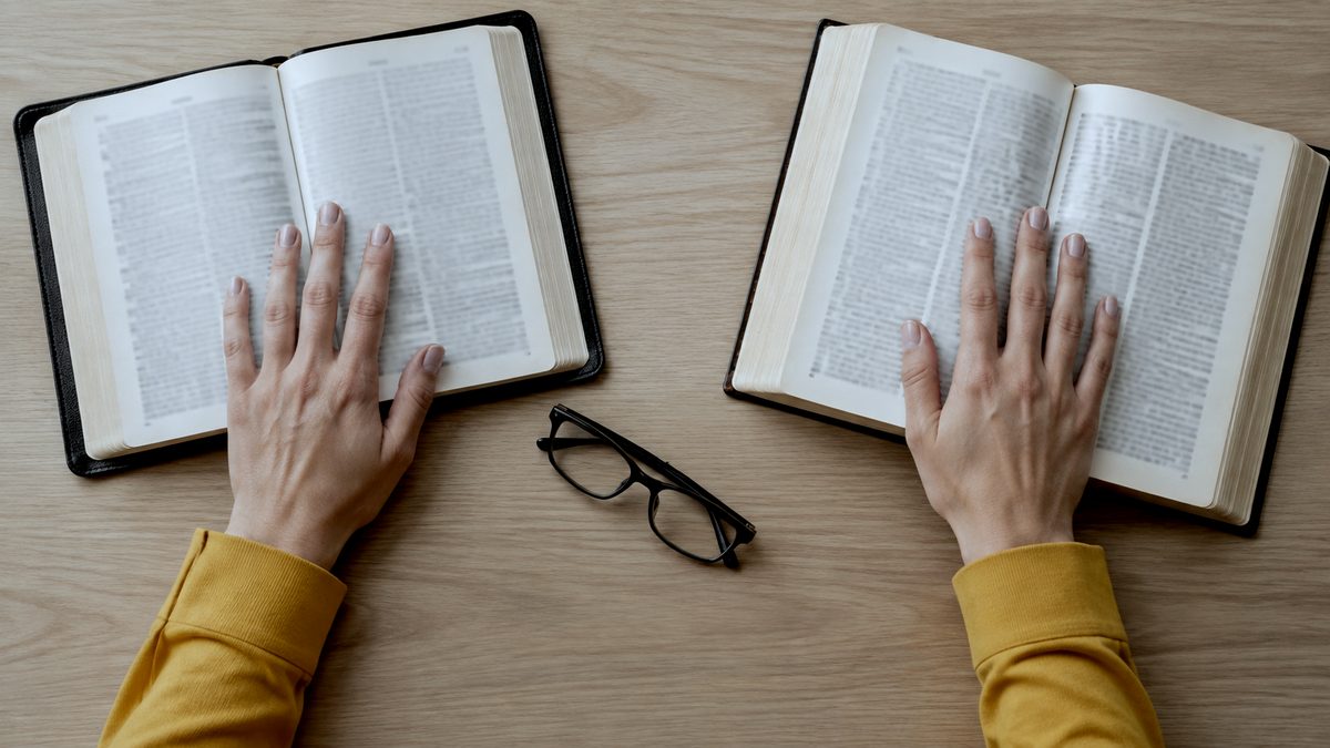 Duas Bíblias Abertas Lado a Lado em Romanos e Hebreus para Comparar Propiciação e Propiciatório